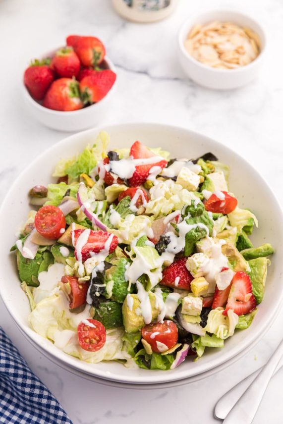 Adding toppings to Strawberry and Avocado Salad