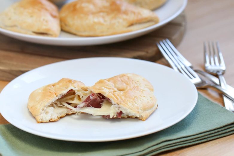 Tearing into a Biscuit Wrapped Reuben Sandwich