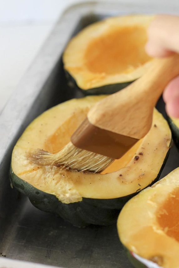 Brushing squash for Rosemary Pork, Kale and Brown Rice Stuffed Acorn Squash