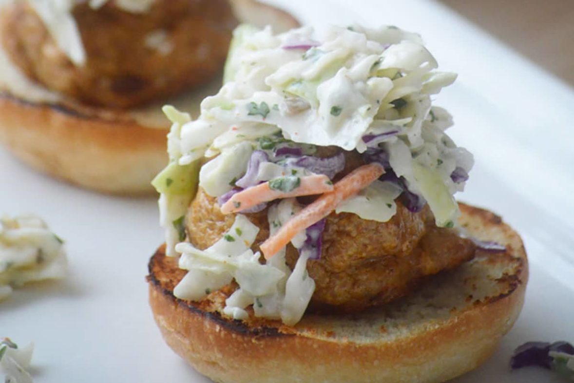 Adding the final touches to Smokey Chicken Meatball Sliders with Jalapeno Slaw