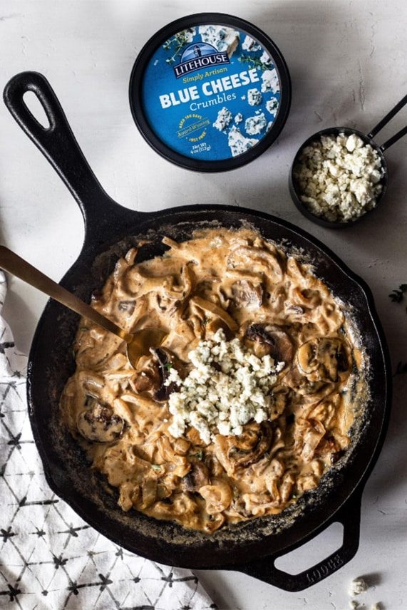 Hot skillet of steaks with creamy blue cheese sauce