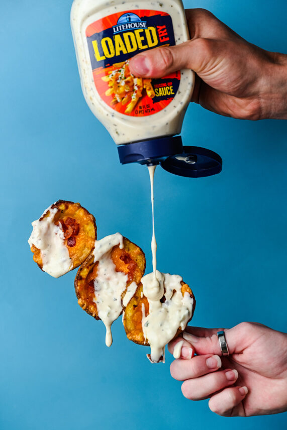 Loaded potato skins covered with Litehouse's Loaded Fry Sauce leaving them dripping with deliciousness